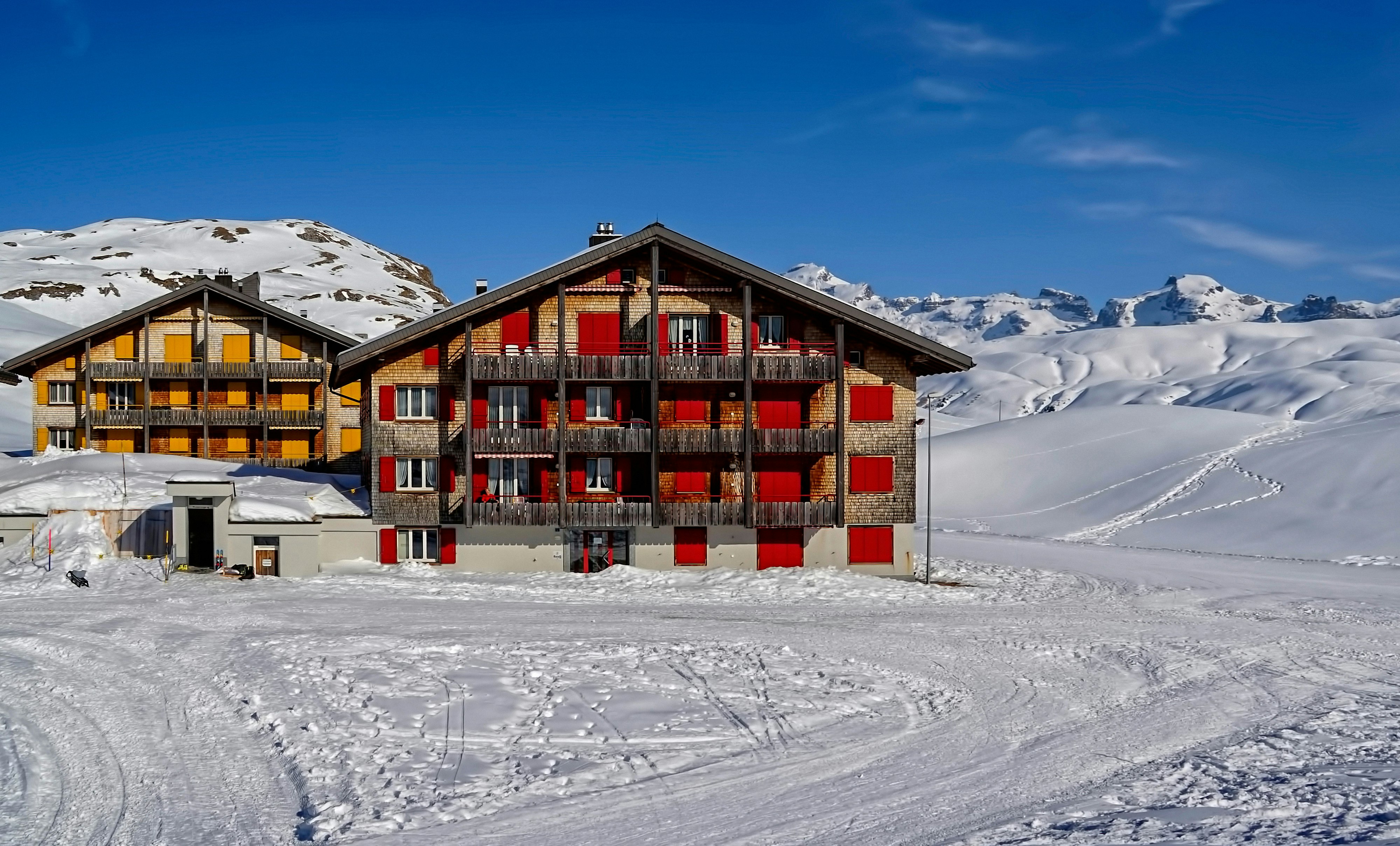 two red and yellow houses surrounded by snowfield at daytime